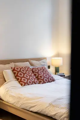 a bed with red and white pillows on it at A Marbled Touched Haven in Antwerp