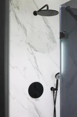 a shower with a white marble wall at A Marbled Touched Haven in Antwerp