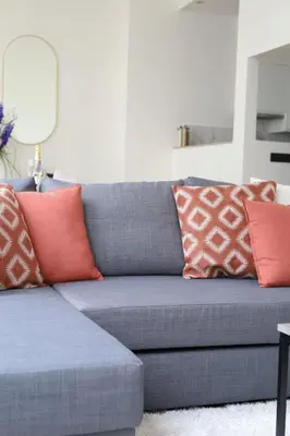 a blue couch with red and orange pillows on it at A Marbled Touched Haven in Antwerp