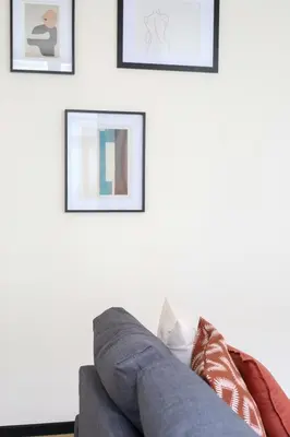 a gray couch sitting in a living room with framed pictures at A Marbled Touched Haven in Antwerp