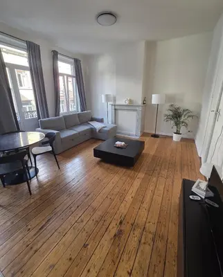 a living room with a couch and a table at La Suite Eleonore in Brussels