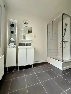 a bathroom with a shower and a tiled floor at La Suite Eleonore in Brussels