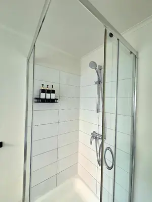 a bathroom with a shower with a glass door at La Suite Eleonore in Brussels