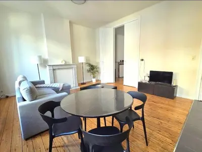 a living room with a table and chairs and a couch at La Suite Eleonore in Brussels