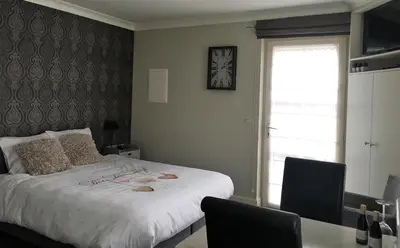a bedroom with a bed and a table and a window at Guesthouse De Middelvelden in Arendonk