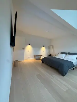 a bedroom with a bed and a flat screen tv at The Gallery Saint-Gilles in Brussels
