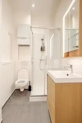 a white bathroom with a toilet and a shower at The Gallery Saint-Gilles in Brussels