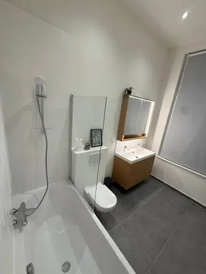 a white bathroom with a toilet and a sink at The Gallery Saint-Gilles in Brussels