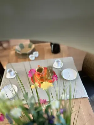 a table with flowers and plates on a table at Guesthouse Eekhoorn 16 in Kasterlee