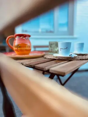 a wooden table with a coffee cup and a vase at Guesthouse Eekhoorn 16 in Kasterlee