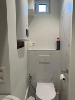 a white bathroom with a toilet and a sink at Hotel Room - Centrum Ghent Leie in Ghent