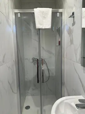 a shower with a glass door next to a sink at Hotel Room - Centrum Ghent Leie in Ghent