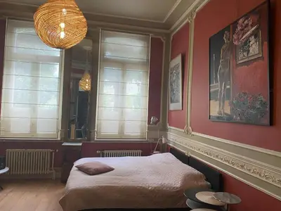 a bedroom with a bed in a room with red walls at Prinsenhof in Ghent