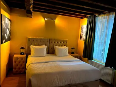 a bedroom with a bed with white sheets and a window at Family Heritage Grand Place in Brussels
