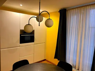 a kitchen with a table and a microwave and two lights at Family Heritage Grand Place in Brussels
