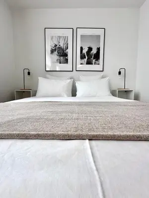 a large white bed with three pictures on the wall at Wonderful apartment in Sablon in Brussels