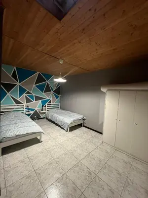 a bedroom with two beds and a wooden ceiling at Midi Tracks Apartment in Brussels