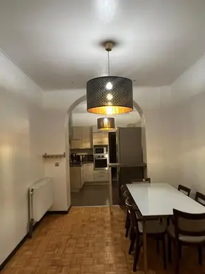 a dining room and kitchen with a table and chairs at Midi Tracks Apartment in Brussels