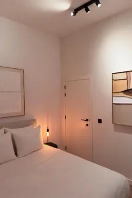 a bedroom with a white bed and a door at Cosy 2-Room Apartment for 4 Guests near Gent Sint-Pieters Station, and Close to the City Centre in Ghent