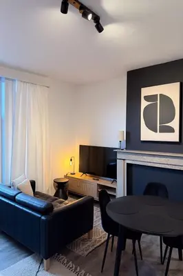 a living room with a couch and a table at Cosy 2-Room Apartment for 4 Guests near Gent Sint-Pieters Station, and Close to the City Centre in Ghent