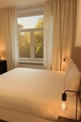 a bedroom with a white bed and a window at Cosy 2-Room Apartment for 4 Guests near Gent Sint-Pieters Station, and Close to the City Centre in Ghent