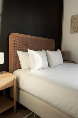 a bedroom with a bed with white pillows and a table at Cosy 2-Room Apartment for 4 Guests near Gent Sint-Pieters Station, and Close to the City Centre in Ghent