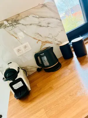 a phone sitting on a table next to two cups at Skyline Duplex Brussels Parking Fibre Modernité in Brussels