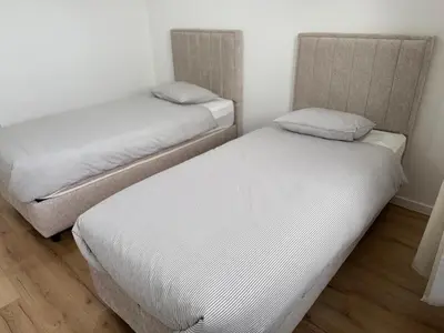 two twin beds in a room with white walls at Skyline Duplex Brussels Parking Fibre Modernité in Brussels