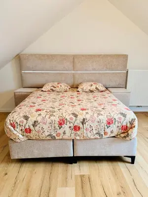 a bed with a floral comforter in a bedroom at Skyline Duplex Brussels Parking Fibre Modernité in Brussels