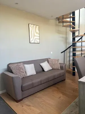 a living room with a couch and a staircase at littoral in Brussels
