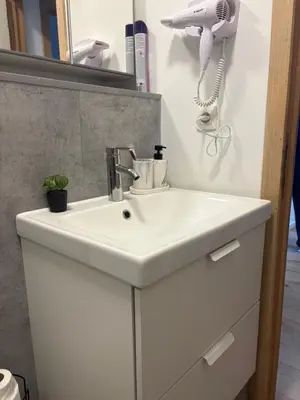 a bathroom with a white sink and a hair dryer at littoral in Brussels