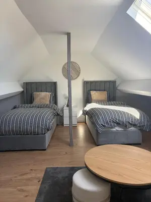 two beds and a table in a room at littoral in Brussels