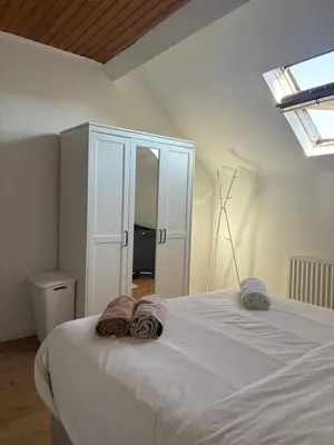 a bedroom with a large white bed with towels on it at littoral in Brussels