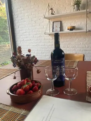 a bottle of wine and two glasses and a bowl of strawberries at Cozy house in Olmen in Balen