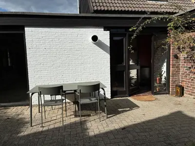 a table and chairs in front of a building at Cozy house in Olmen in Balen