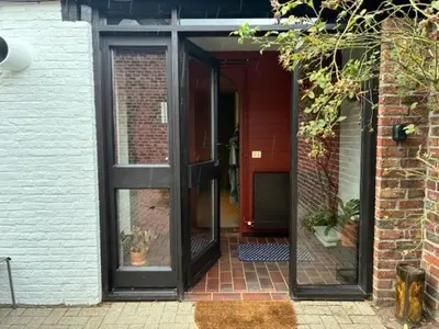 an open door of a brick building with potted plants at Cozy house in Olmen in Balen