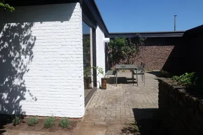 a white building with a table and a patio at Cozy house in Olmen in Balen