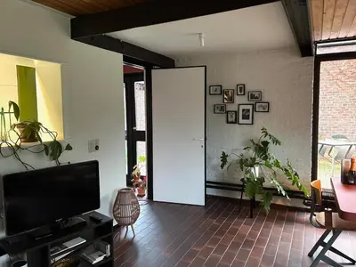 a living room with a white door and plants at Cozy house in Olmen in Balen