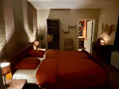 a bedroom with a bed with orange sheets and pillows at Bij Liezeke in Zemst