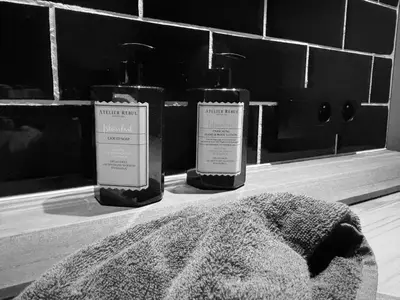 two bottles of soap sitting on a bathroom sink at Bij Liezeke in Zemst