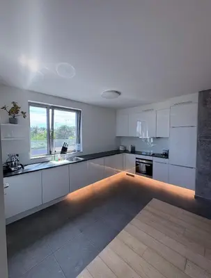 a kitchen with white cabinets and a large window at Refined apartment with terraces in Brussels