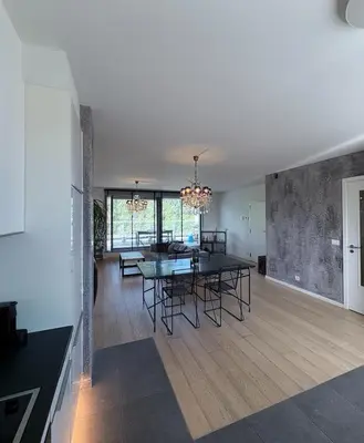 a dining room and living room with a table and chairs at Refined apartment with terraces in Brussels