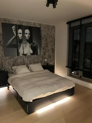 a bedroom with a bed with a poster on the wall at Refined apartment with terraces in Brussels