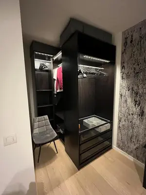a black closet with a chair in a room at Refined apartment with terraces in Brussels