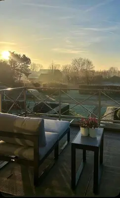a patio with a couch and a table with flowers at De Loft in Melsele