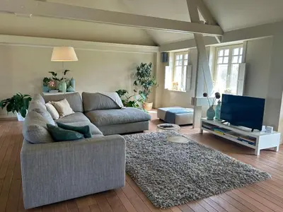 a living room with a couch and a flat screen tv at De Loft in Melsele