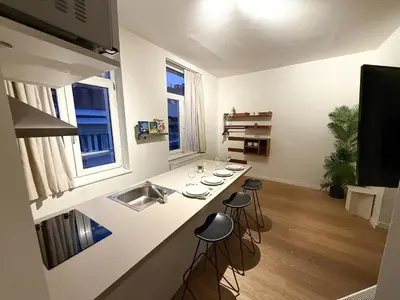 a kitchen with a sink and a counter with stools at Studio 204 cosy au centre de Bruxelles in Brussels