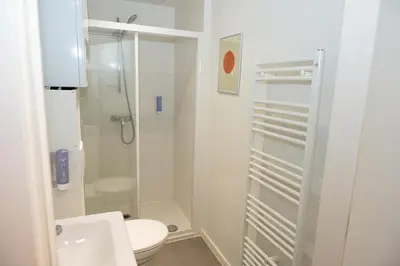 a white bathroom with a shower and a toilet at Studio 204 cosy au centre de Bruxelles in Brussels