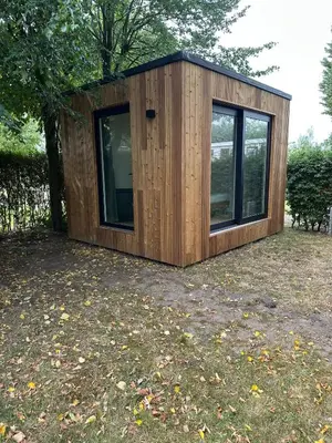 a small wooden house in a yard at Woodboxcabins - Campinggroenpark in Zele