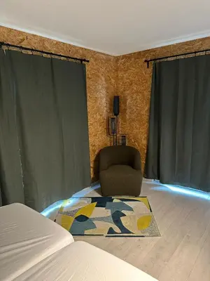 a bedroom with a bed and a chair and a rug at Woodboxcabins - Campinggroenpark in Zele